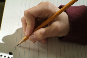 Hand grasping pencil about to write